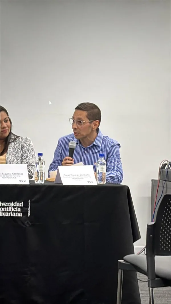 Oscar Doumer exponiendo ideas sobre bienestar y liderazgo frente a audiencia.